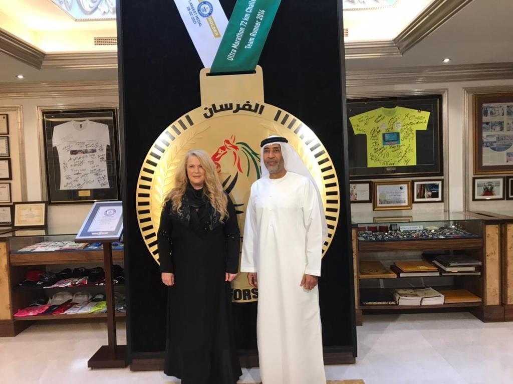 Guild members with a host in front of the Al Forsan emblem